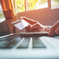 Man holding credit card in hand and entering security code using